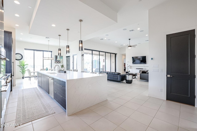 kitchen with ceiling fan, a sink, recessed lighting, light tile patterned floors, and a spacious island