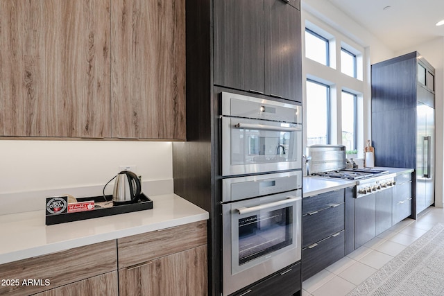 kitchen featuring appliances with stainless steel finishes, light countertops, modern cabinets, and light tile patterned flooring