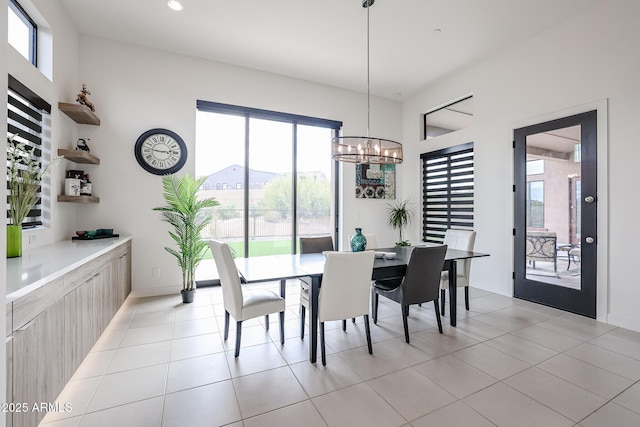 dining area featuring light tile patterned flooring and a notable chandelier