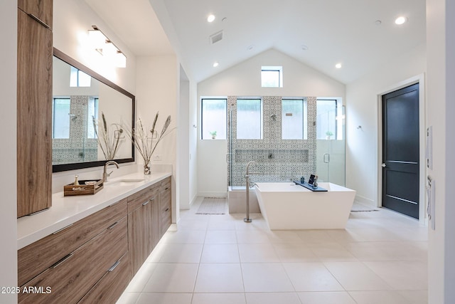 bathroom featuring tile patterned flooring, a shower stall, vanity, lofted ceiling, and a soaking tub