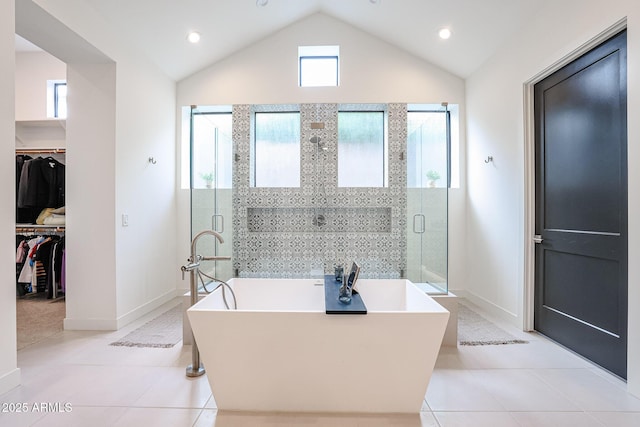 full bathroom with a walk in closet, tile patterned flooring, a soaking tub, and a stall shower