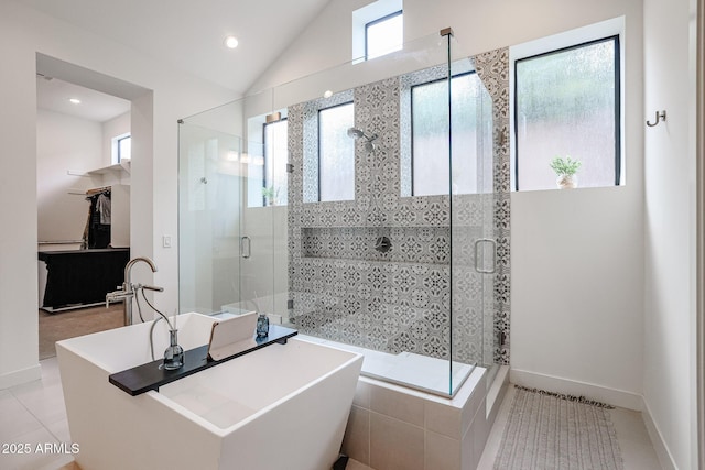 full bath featuring a healthy amount of sunlight, a freestanding tub, and a shower stall