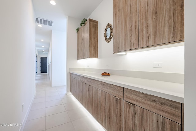 interior space featuring light tile patterned floors, light countertops, modern cabinets, and visible vents
