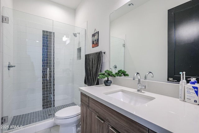 full bathroom featuring vanity, a stall shower, and toilet