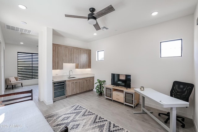 office area with beverage cooler, a sink, plenty of natural light, and visible vents
