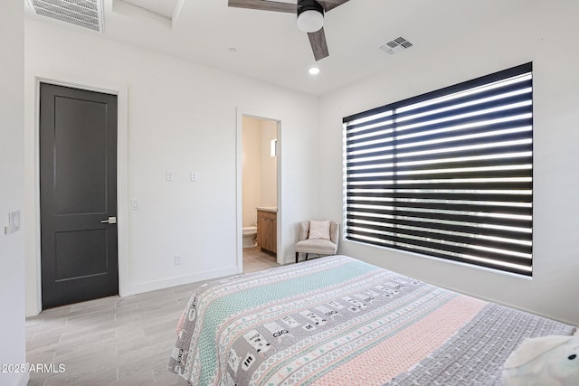 bedroom with baseboards, light wood-type flooring, ensuite bath, and visible vents