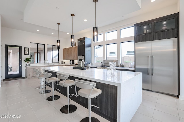 kitchen with stainless steel appliances, recessed lighting, light tile patterned floors, a kitchen bar, and modern cabinets