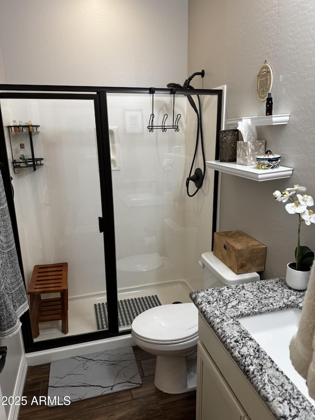 10704 E Twister Ave, Mesa, AZ 85212 - bathroom featuring wood finished floors, vanity, a stall shower, and toilet