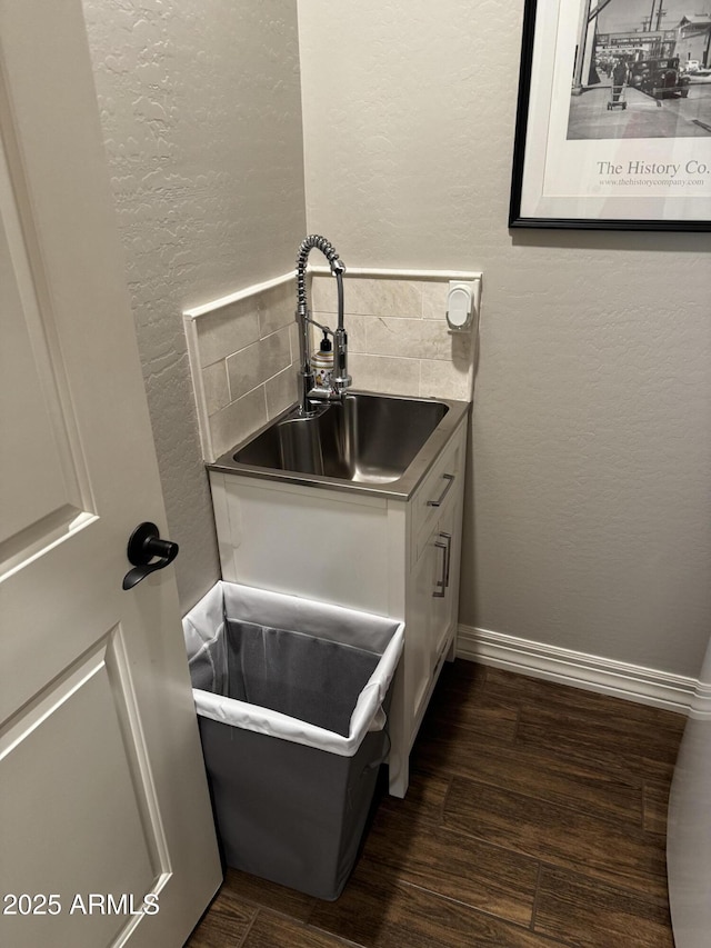 10704 E Twister Ave, Mesa, AZ 85212 - detailed view of a sink, a textured wall, wood finished floors, and decorative backsplash