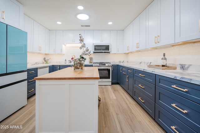 kitchen featuring white cabinetry, stainless steel range, a center island, and blue cabinetry