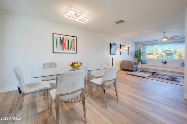 dining space with light hardwood / wood-style flooring and ceiling fan