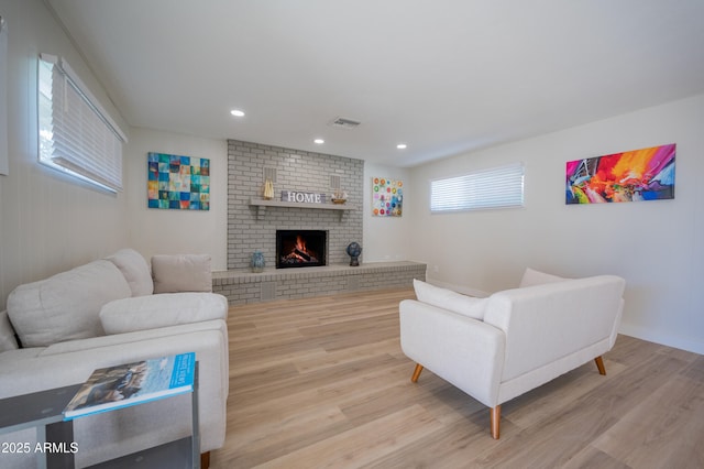 living room with a fireplace and light hardwood / wood-style flooring