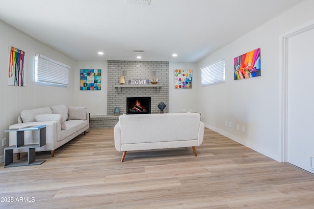 living room with light wood-type flooring and a fireplace