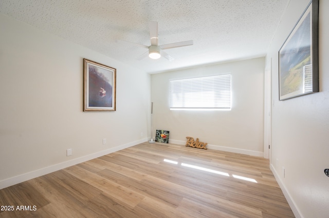 spare room featuring ceiling fan, light hardwood / wood-style flooring, and a textured ceiling