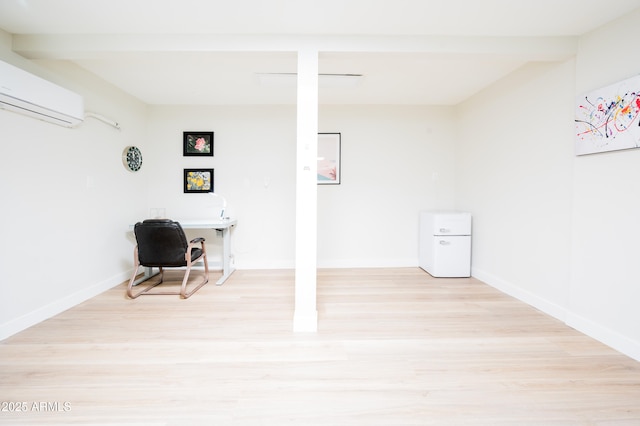 basement featuring an AC wall unit and light wood-type flooring