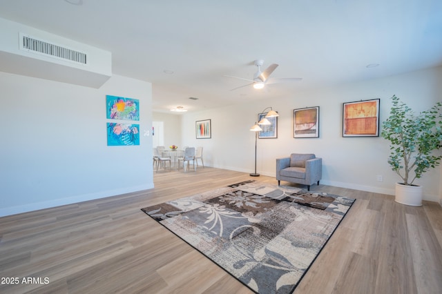 sitting room with ceiling fan and light wood-type flooring