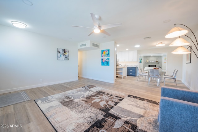 living room featuring ceiling fan and light wood-type flooring