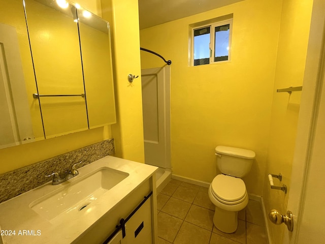 bathroom featuring a shower, vanity, tile patterned flooring, and toilet