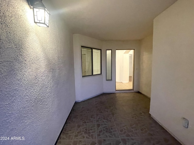 hallway featuring dark tile patterned flooring