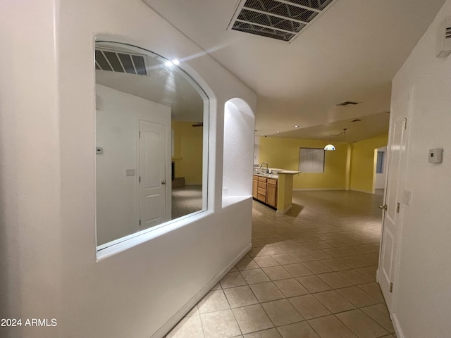 hall with sink and light tile patterned flooring