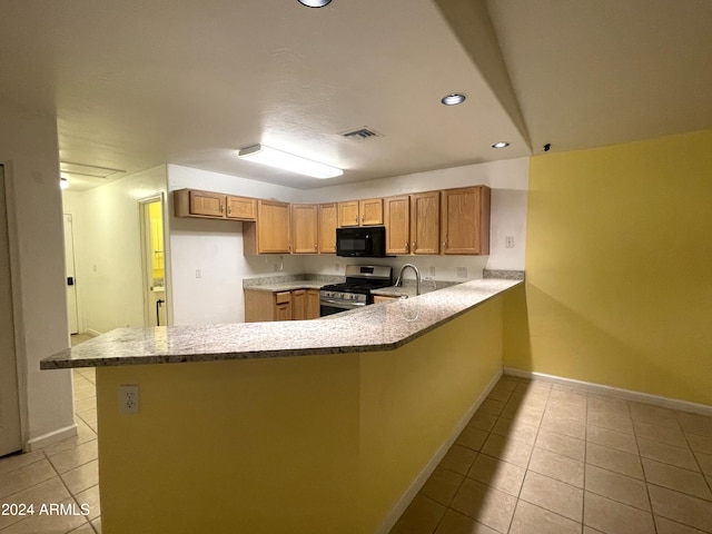 kitchen featuring kitchen peninsula, light tile patterned floors, stainless steel range with gas cooktop, and sink