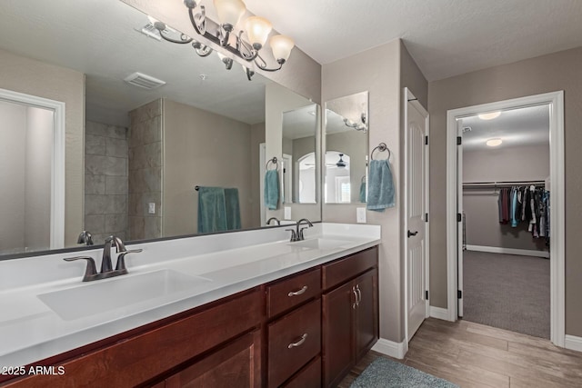 bathroom with visible vents, a sink, baseboards, and double vanity