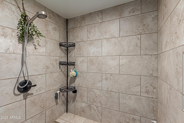 interior details featuring a tile shower