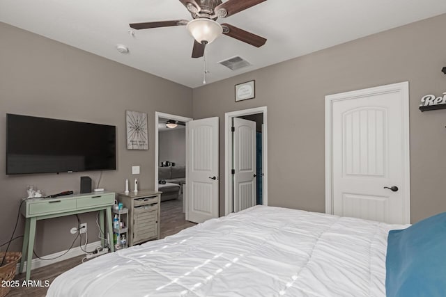 bedroom with baseboards, ceiling fan, visible vents, and wood finished floors