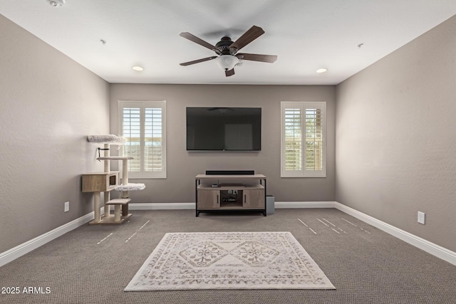 carpeted living room featuring ceiling fan and baseboards