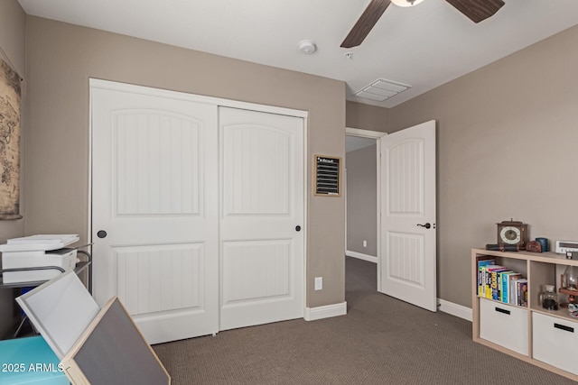 office space featuring a ceiling fan, visible vents, dark carpet, and baseboards