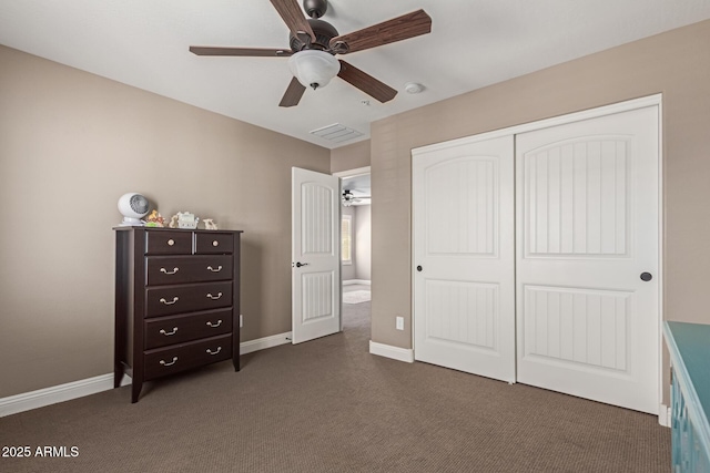 unfurnished bedroom with a ceiling fan, baseboards, dark carpet, and a closet