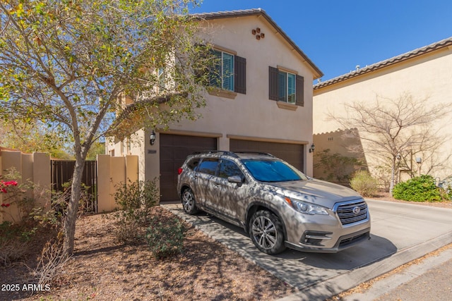 view of front of property featuring driveway, an attached garage, and stucco siding