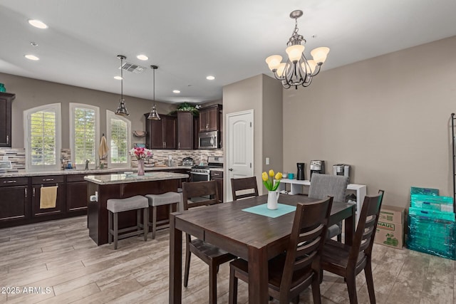 dining space featuring light wood-style floors, visible vents, a chandelier, and recessed lighting