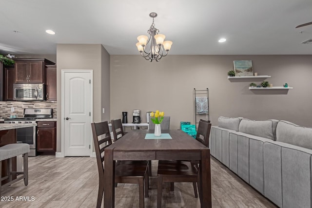 dining space with a chandelier, light wood-type flooring, visible vents, and recessed lighting