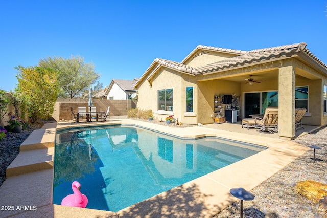 rear view of property with a patio, a tiled roof, a ceiling fan, and stucco siding