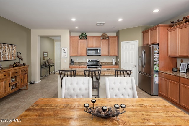 kitchen featuring a center island with sink, visible vents, stainless steel appliances, and recessed lighting