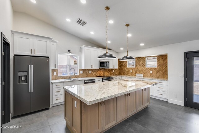 3011 E John Cabot Dr, Phoenix, AZ 85032 - kitchen featuring appliances with stainless steel finishes, lofted ceiling, a sink, a kitchen island, and backsplash