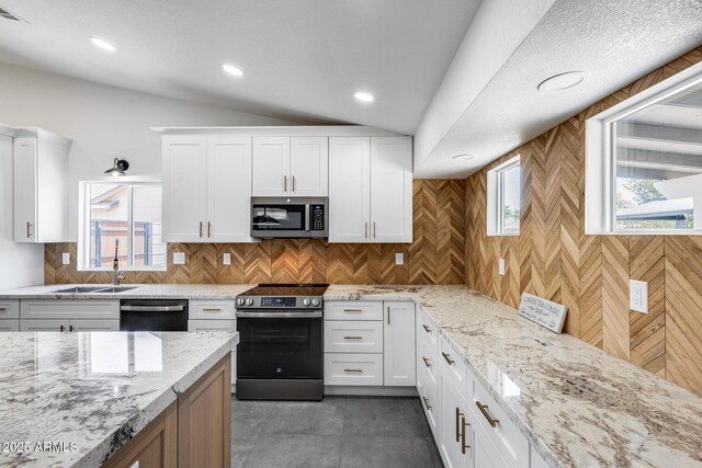 3011 E John Cabot Dr, Phoenix, AZ 85032 - kitchen with stainless steel appliances, a sink, lofted ceiling, white cabinetry, and healthy amount of natural light