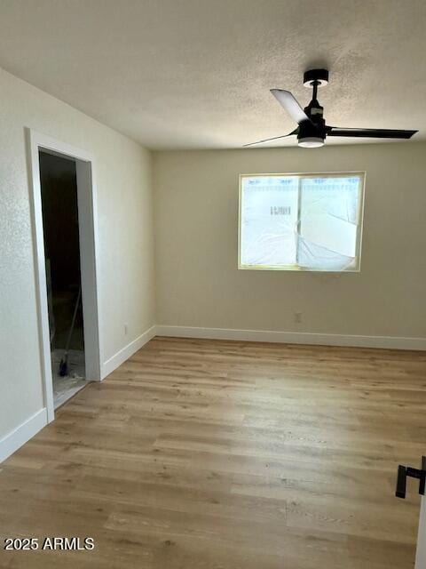 empty room featuring baseboards, ceiling fan, and wood finished floors