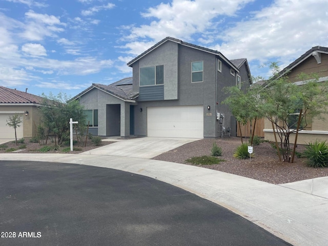2364 N 212th Ave, Buckeye, AZ 85396 - view of front facade with stucco siding, an attached garage, driveway, roof mounted solar panels, and a tile roof