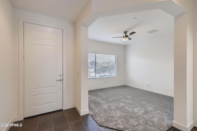 2364 N 212th Ave, Buckeye, AZ 85396 - entryway with dark colored carpet, a ceiling fan, dark tile patterned flooring, and baseboards