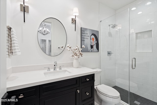 bathroom featuring vanity, a shower with shower door, and toilet