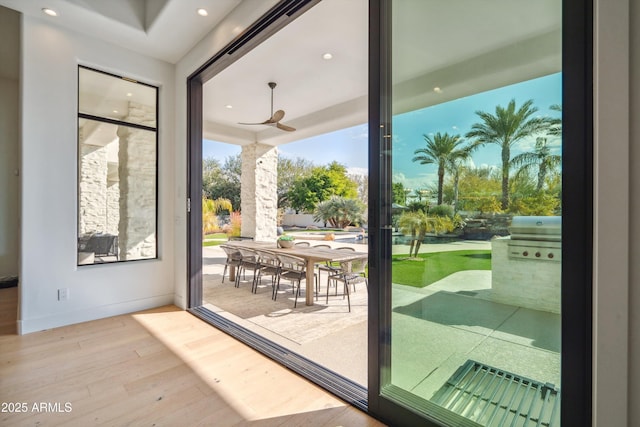 doorway to outside with ceiling fan and light hardwood / wood-style flooring