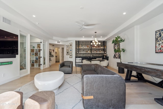 living room featuring a notable chandelier and light wood-type flooring