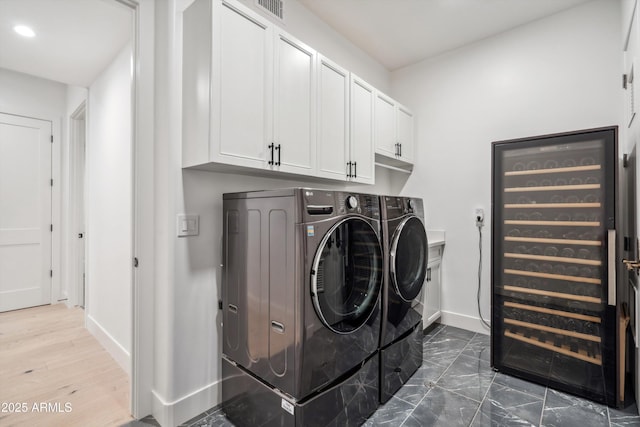 clothes washing area featuring cabinets and washing machine and dryer