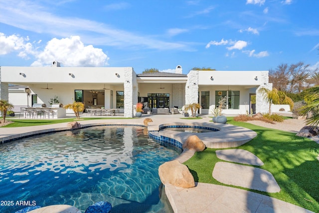 rear view of house featuring ceiling fan, a pool with hot tub, and a patio