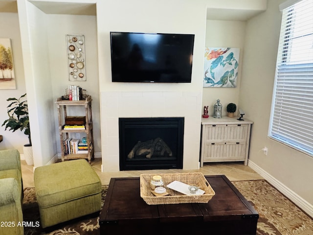 tiled living area featuring baseboards and a tile fireplace