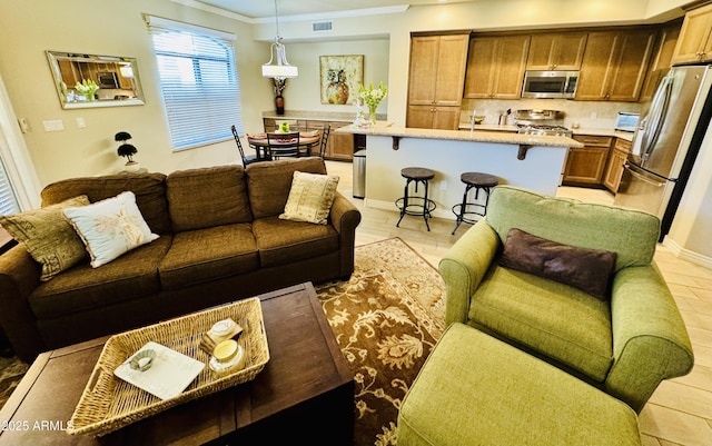 living area featuring crown molding, visible vents, and baseboards