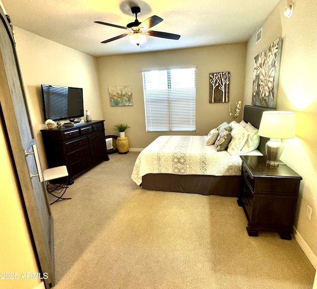 bedroom with ceiling fan, light carpet, baseboards, and visible vents
