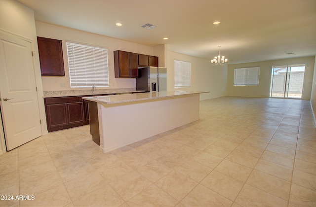 kitchen featuring a notable chandelier, decorative light fixtures, stainless steel fridge with ice dispenser, a center island, and light tile patterned floors